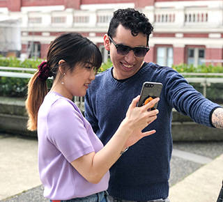 two students checking social media on their phone